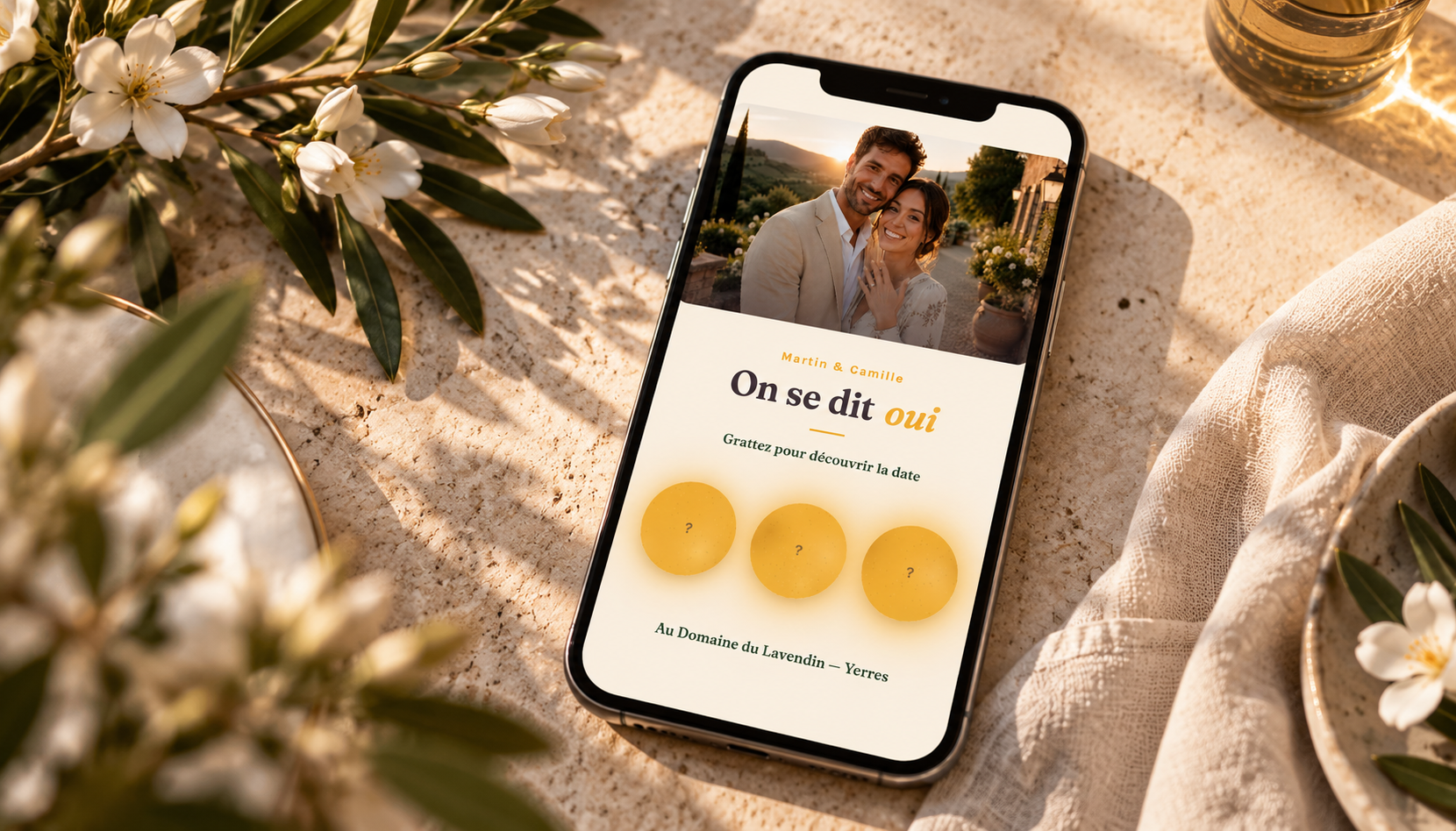 Smartphone affichant une invitation ECHO « On se dit oui » posé sur une table crème aux fleurs blanches